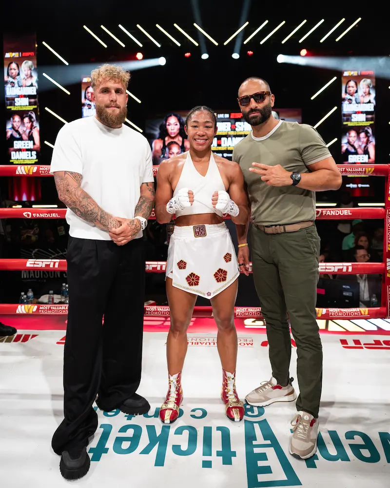 Celebrities posing in th ering for a photo with the Event Tickets Center Logo on the floor representing sponsorship.