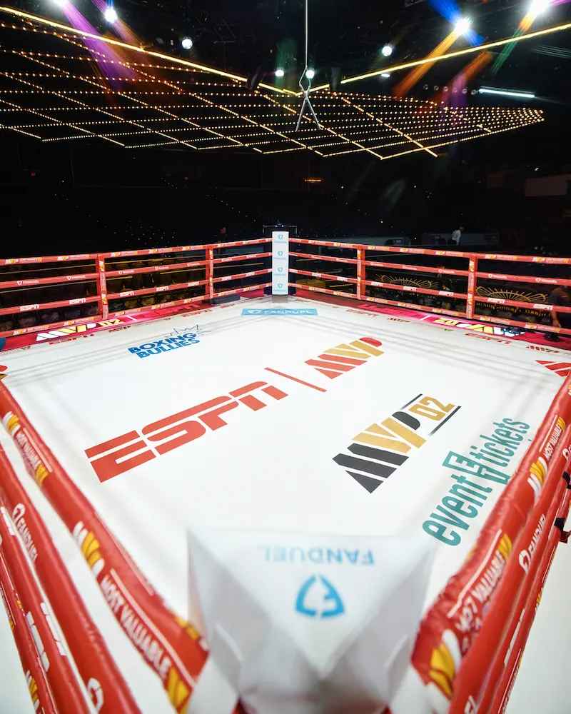 A boxing ring with several sponsorships on the floor including Event Tickets Center.