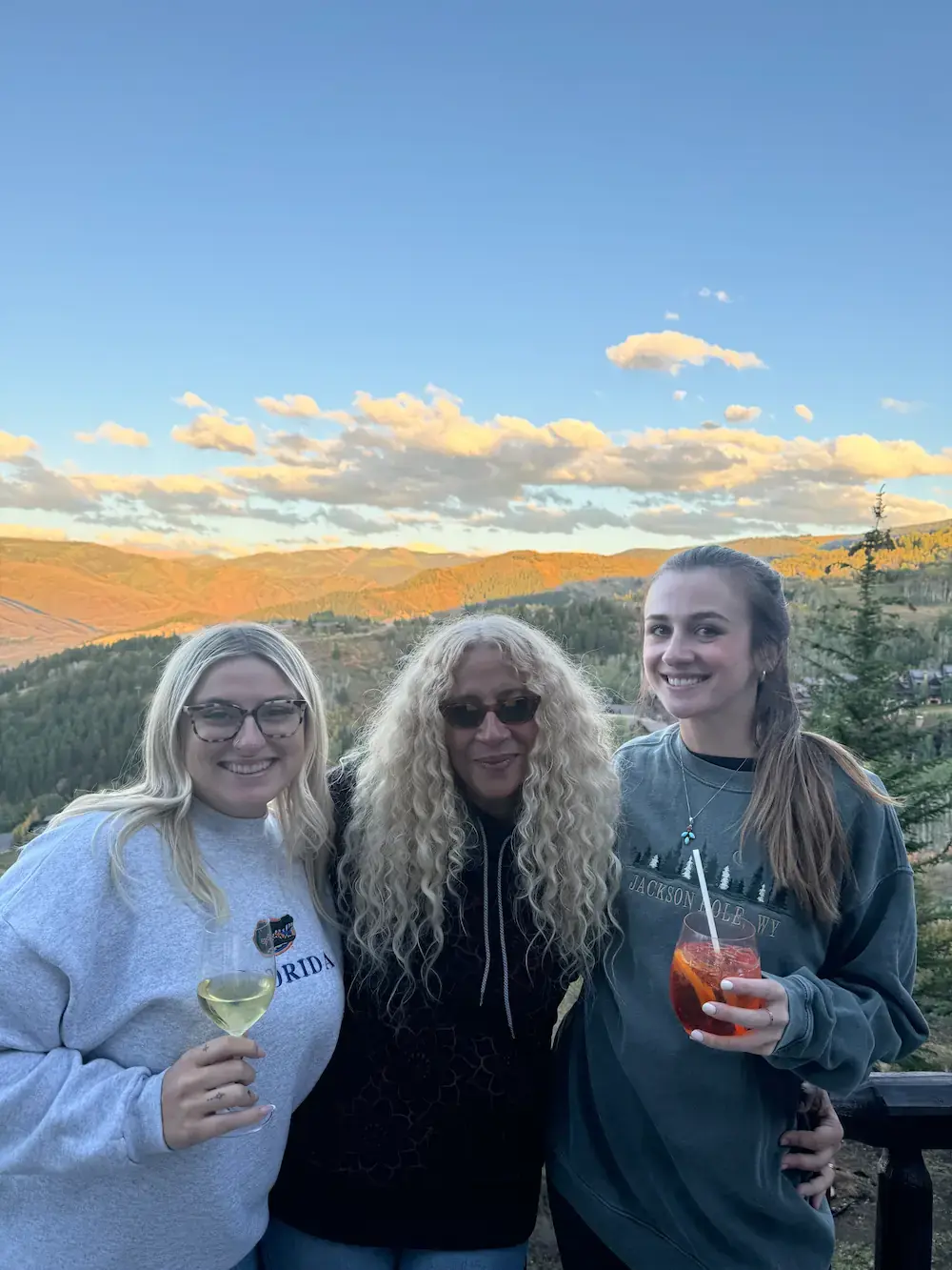 Three ETC team members posing for a photo in front of a mountain range