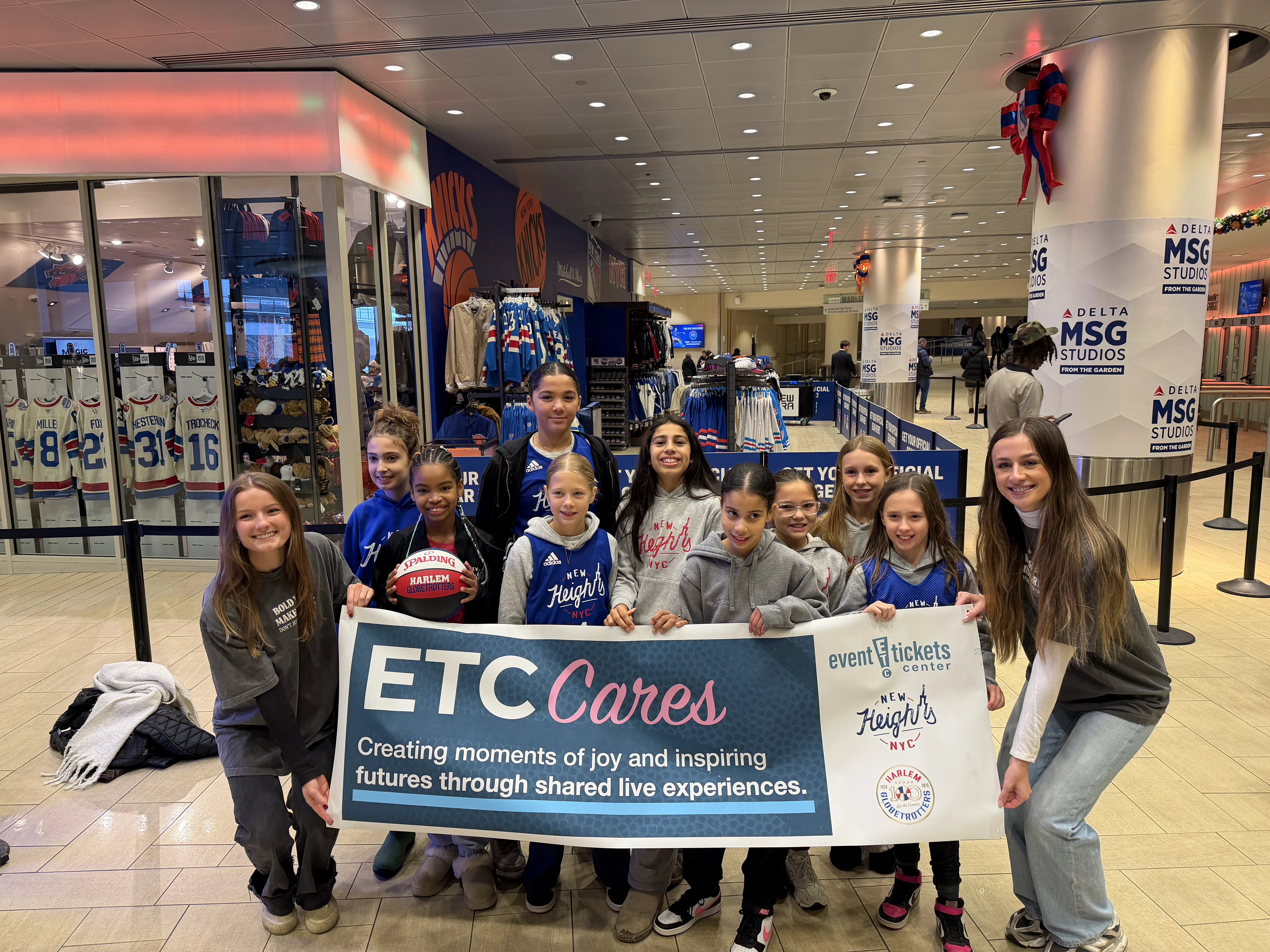 Event Tickets Center team members posing with kids of the Globetrotters new heights program