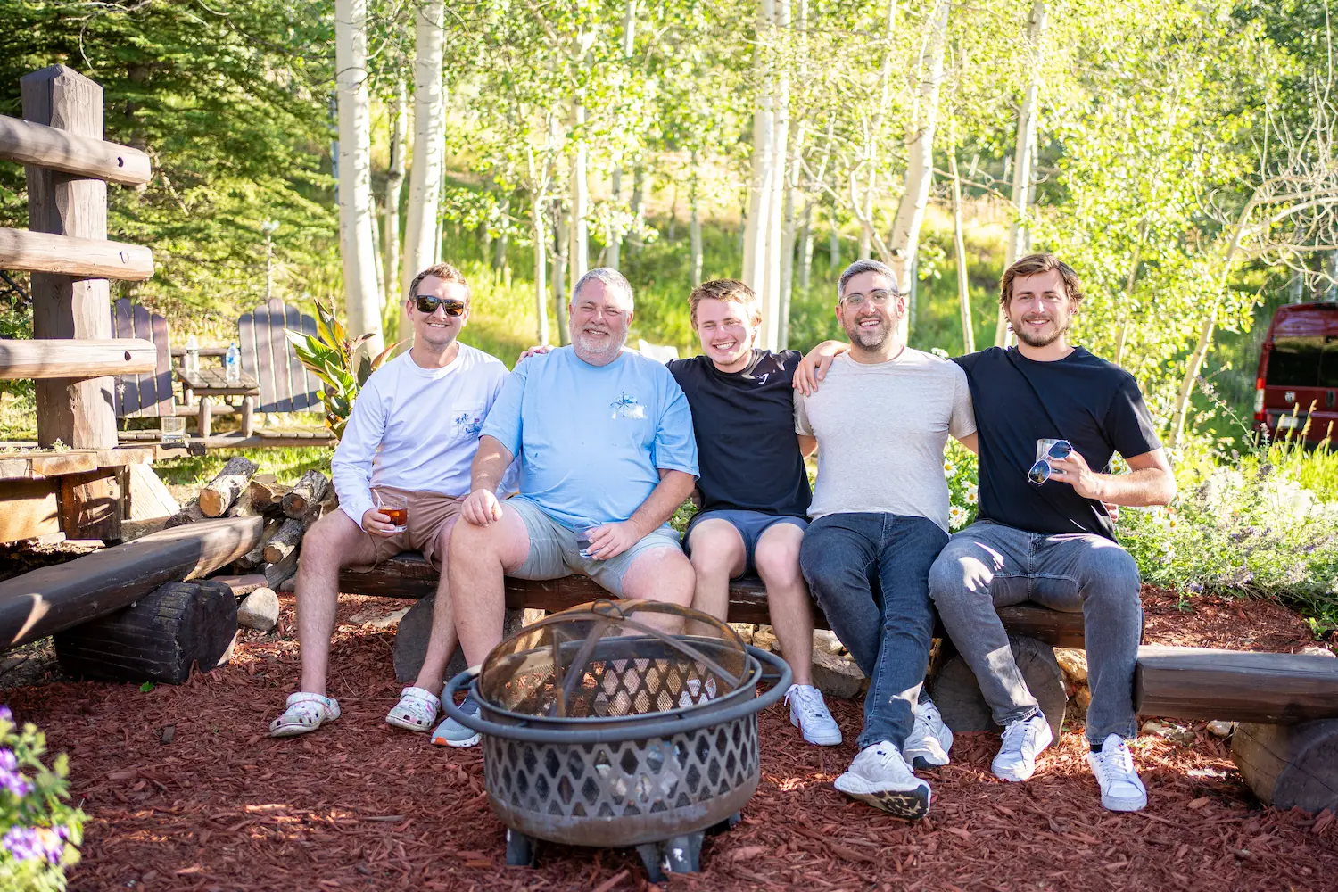 ETC team members sitting on a log bench smiling for a photo 