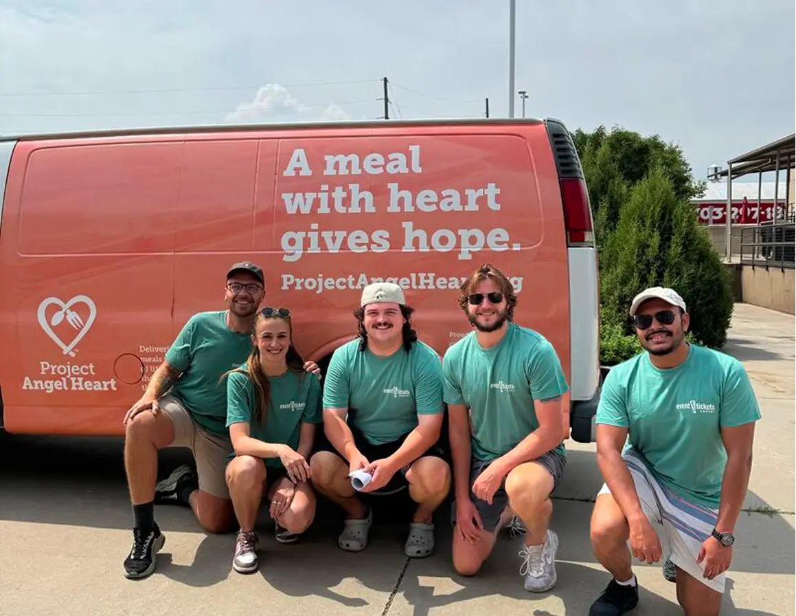 ETC Team Members kneeling down and posing for a photo in front of a Project Angel Heart van