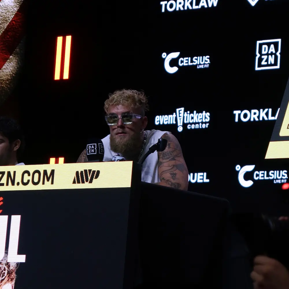 Jake Paul speaking at a press conference with ETC logo behind him
