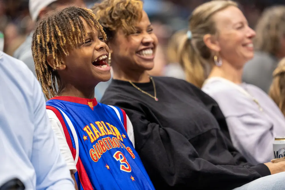 A young fan of the Harlem Globetrotters cheering at a Globetrotters event